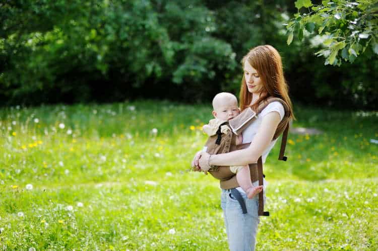 Petite mother with baby in carrier