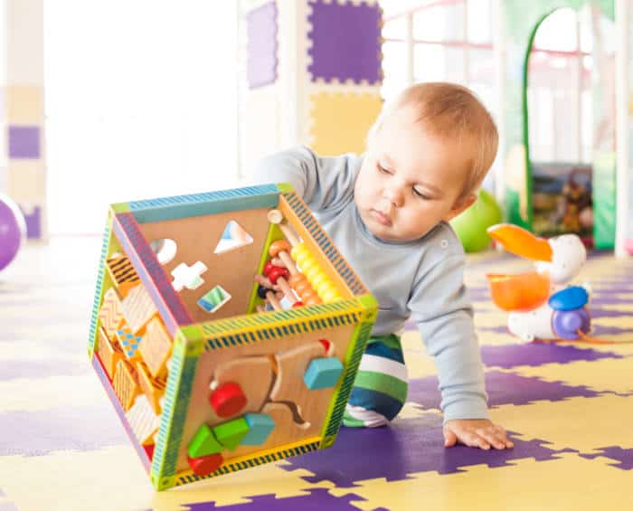 baby boy playing with an activity cube