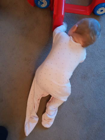 Baby crawling out of a sleep suit