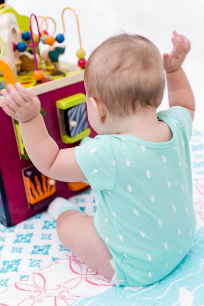 Baby sitting in front of an activity cube