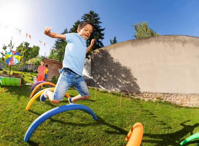 Child jumping over obstacles outside on a sunny day