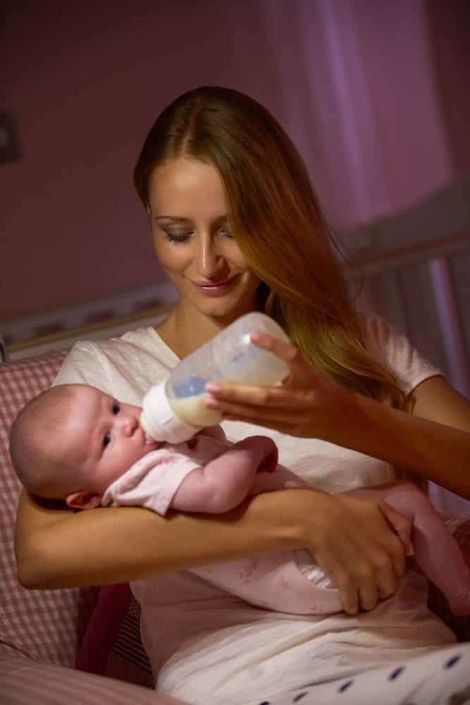 Mother feeding baby a bottle of formula a night
