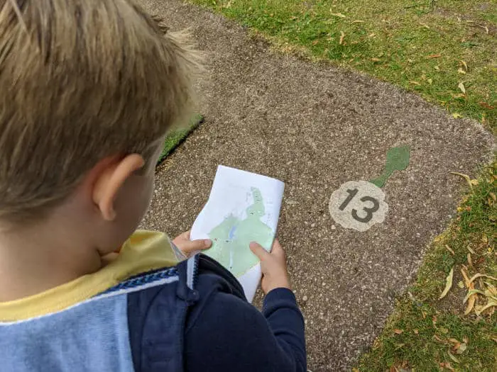 Boy looking at a map and finding a number on the floor