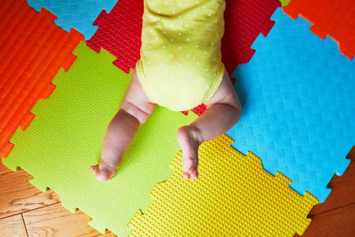 baby crawling on a foam floor mat