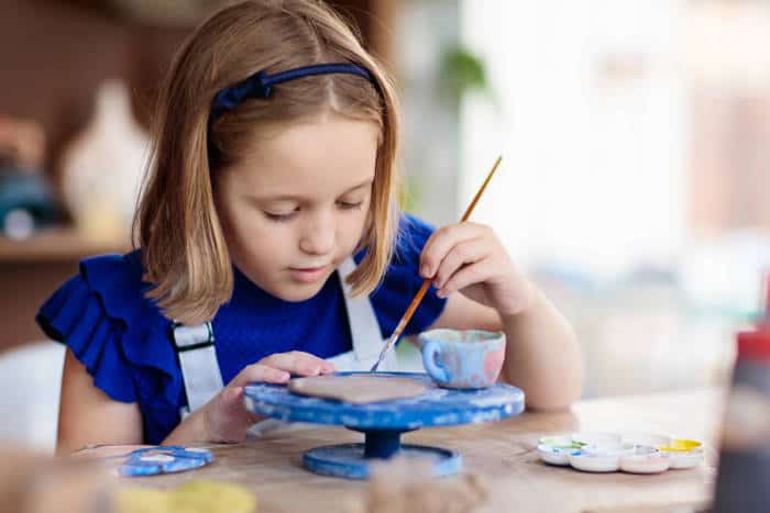 young girl working on a craft or pottery wheel