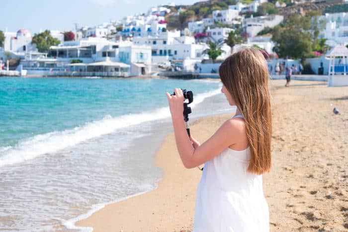 Girl with GoPro action camera on the beach