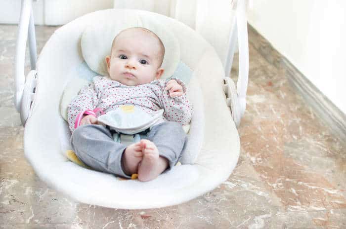 baby in an electronic baby swing seat