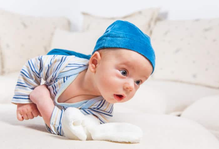 Baby rolling over playing with a fluffy toy